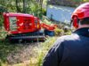 Bediener schaut auf funkgesteuerte Baumstumpffräse