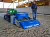 Fungesteuerte Raupe mit Sandreinigungsgerät in Reithalle