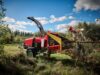 Mann schiebt dicken Ast in TP Holzhacker